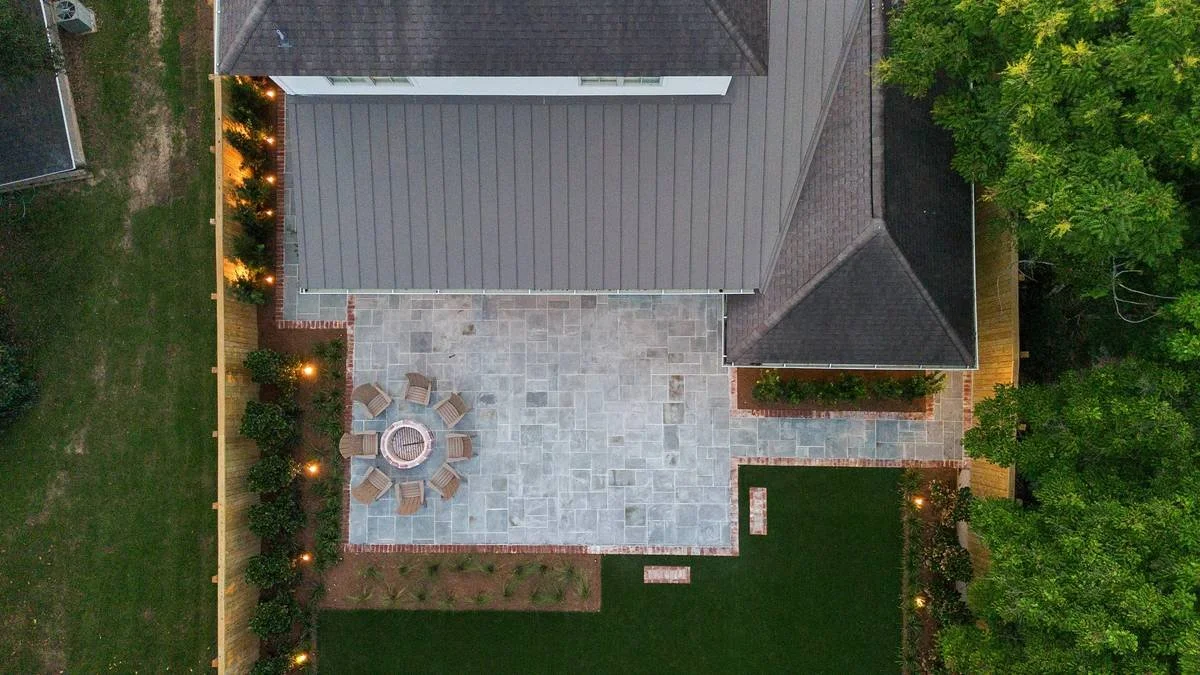 Overhead twilight view of the bluestone terrace, fire pit and lighting — Flora Landscape Contractors
