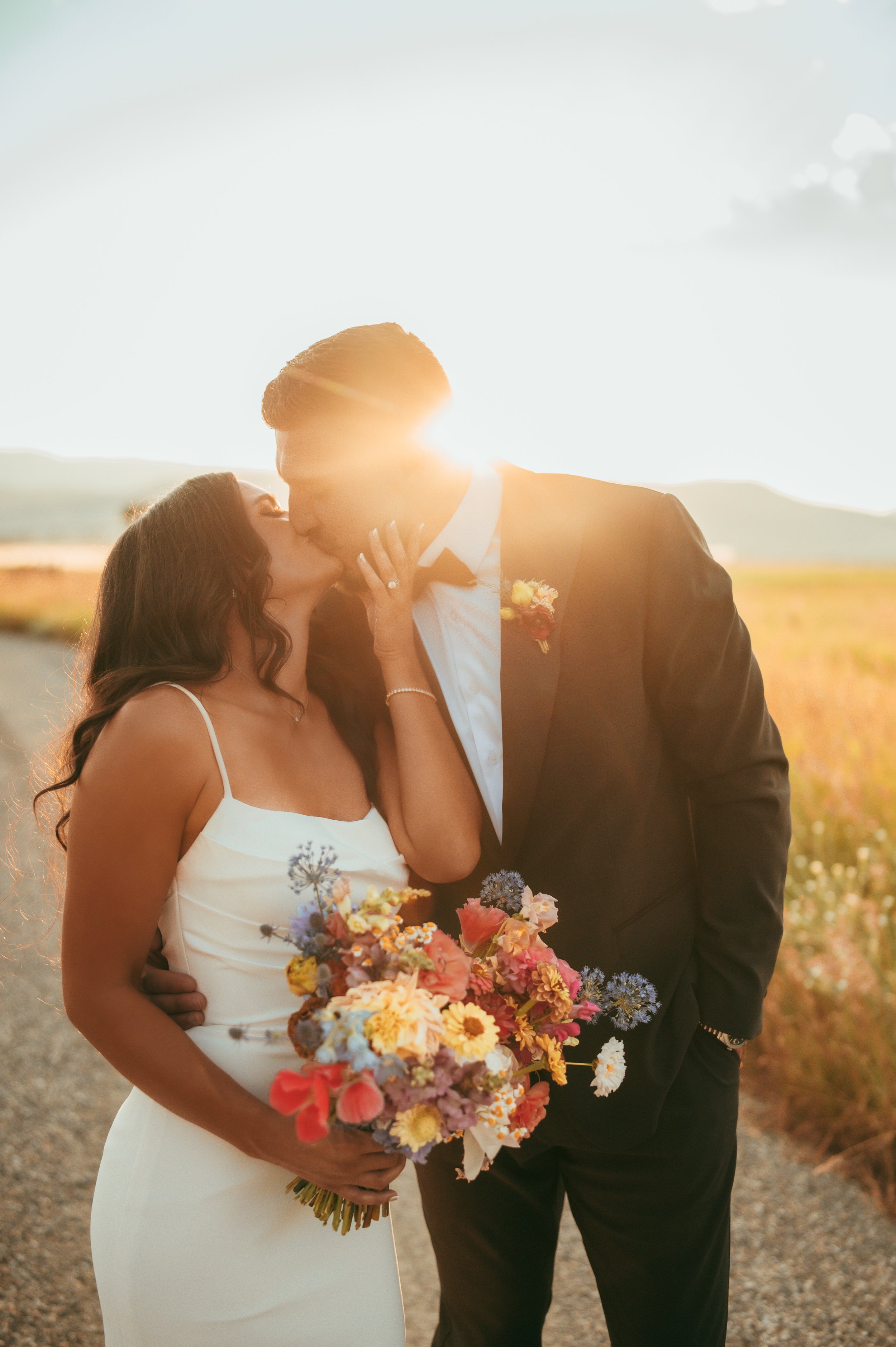 Bride and groom embracing at sunset at Copper Rose Ranch wedding venue in Livingston, Montana during a romantic outdoor Montana wedding.