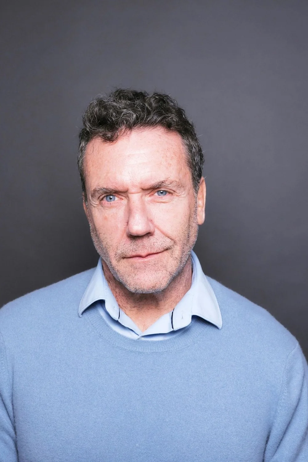 Portrait of Dr. Blaise Aguirre in a light blue sweater