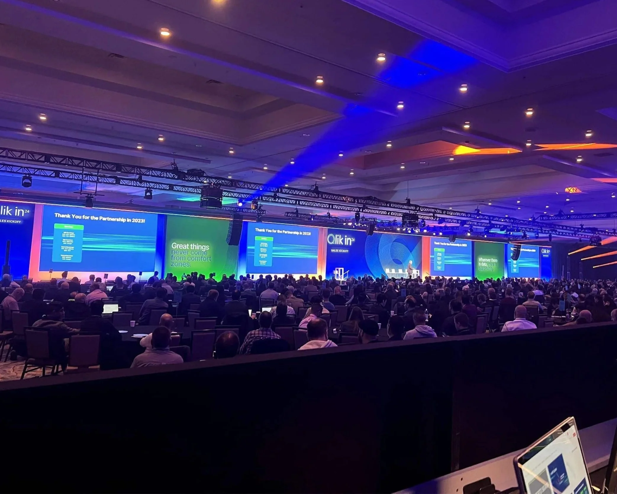 Crowd at event with wall of video screens