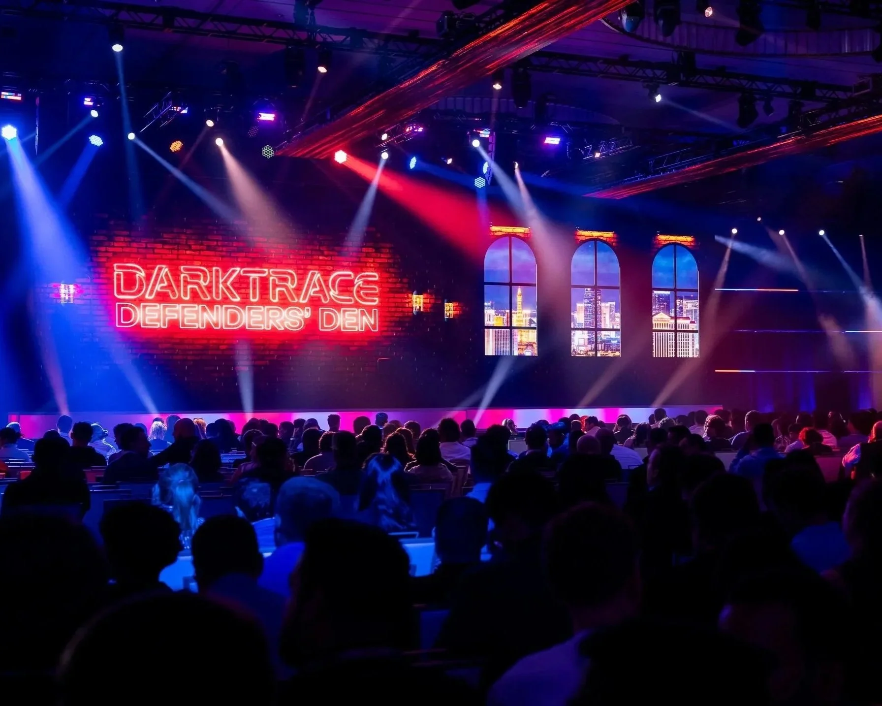 Speaker on stage for Qlik World, with series of open doors on video screen