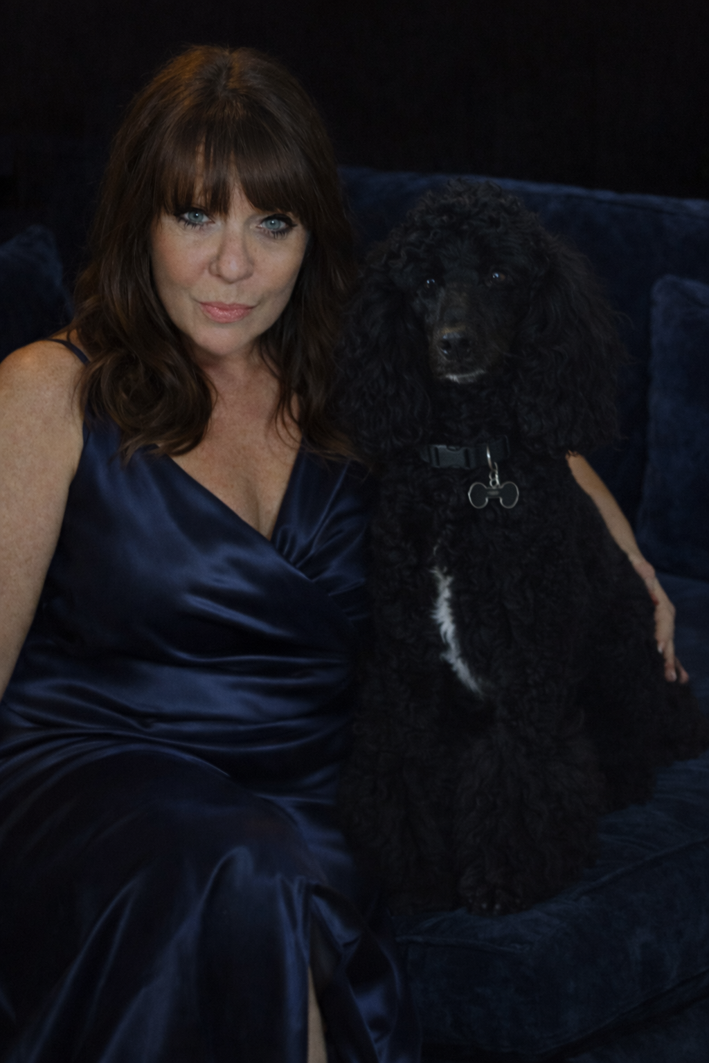Picture of Mea Brown in a blue satin gown with her poodle, Mateo