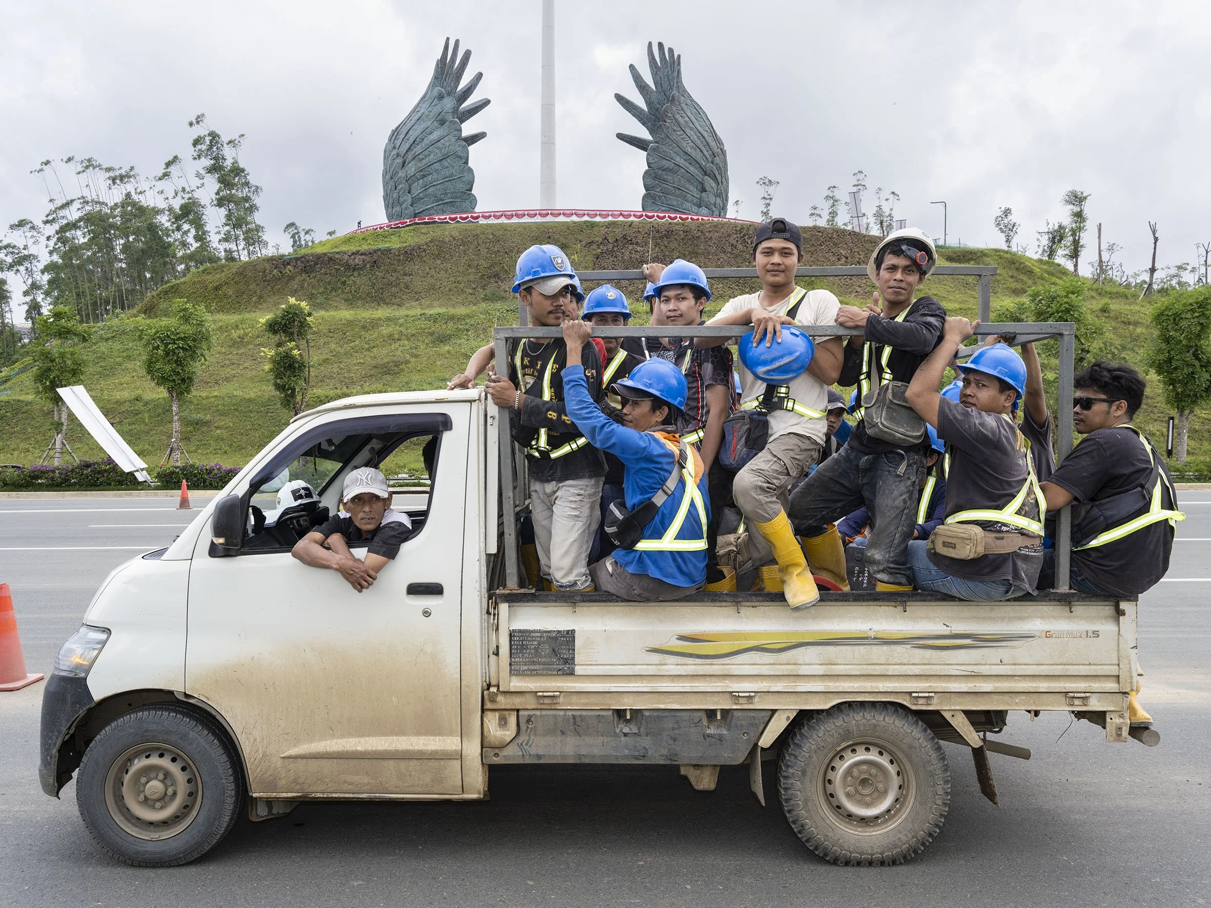 Construction workers drive past the Nusantara Protective Wings monument. August 24, 2025