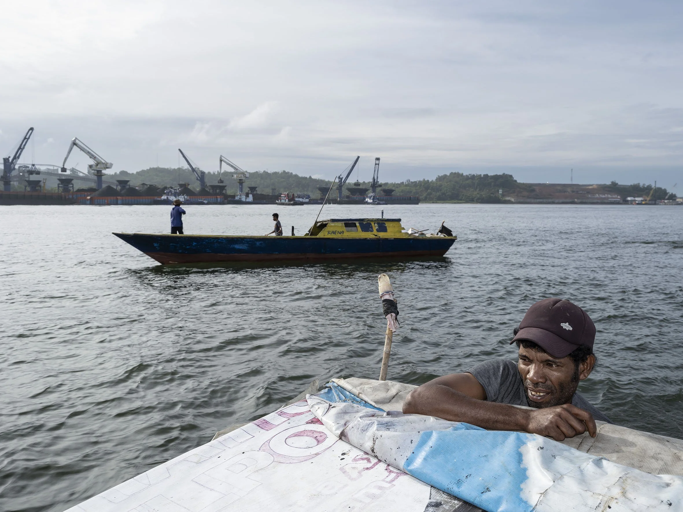 Fishermen sail past the coal-loading dock in Balikpapan Bay. They complain about declining fish stocks due to industrial pollution. September 6, 2022 
