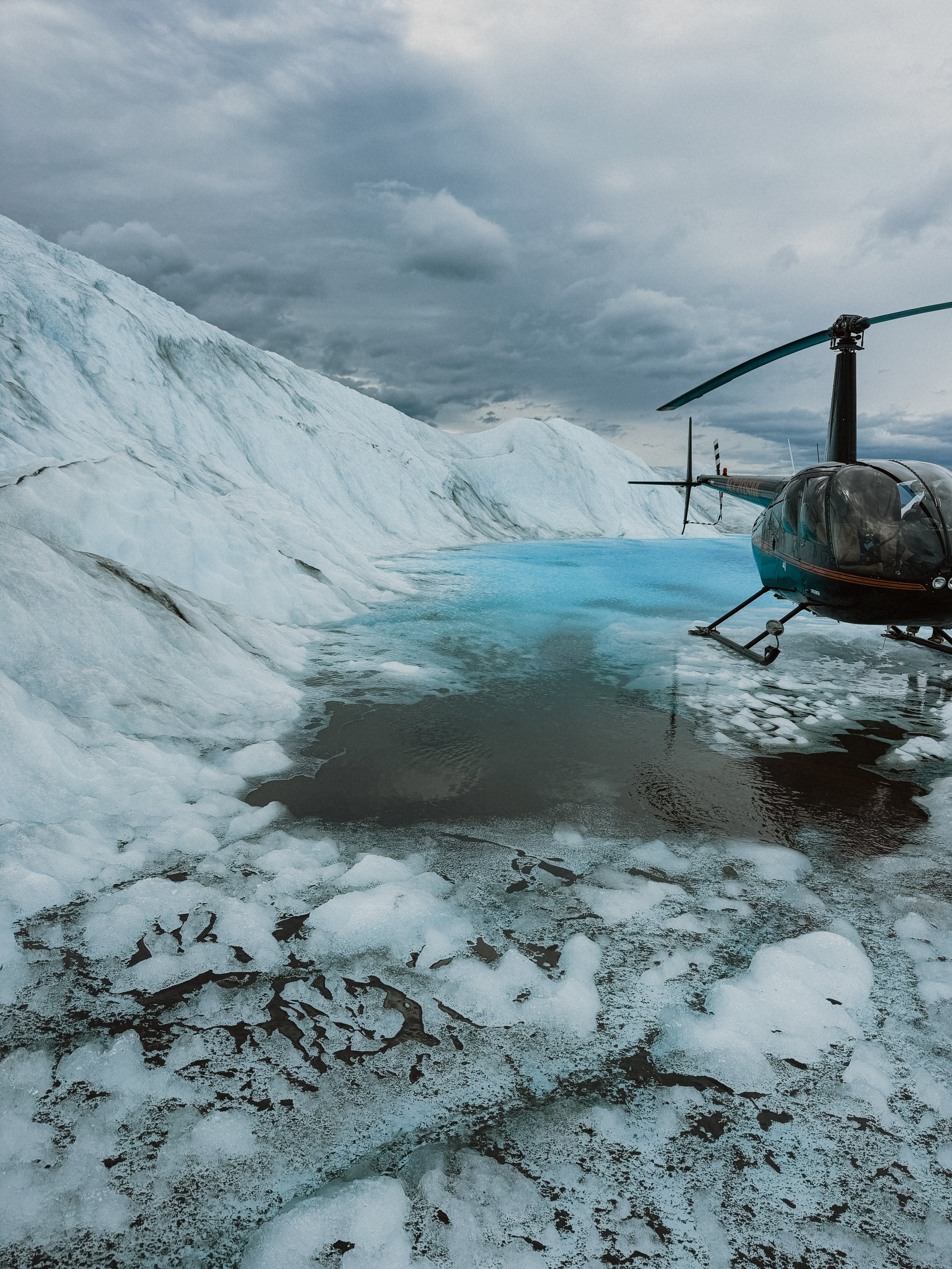 black helicopter on blue glacier pond