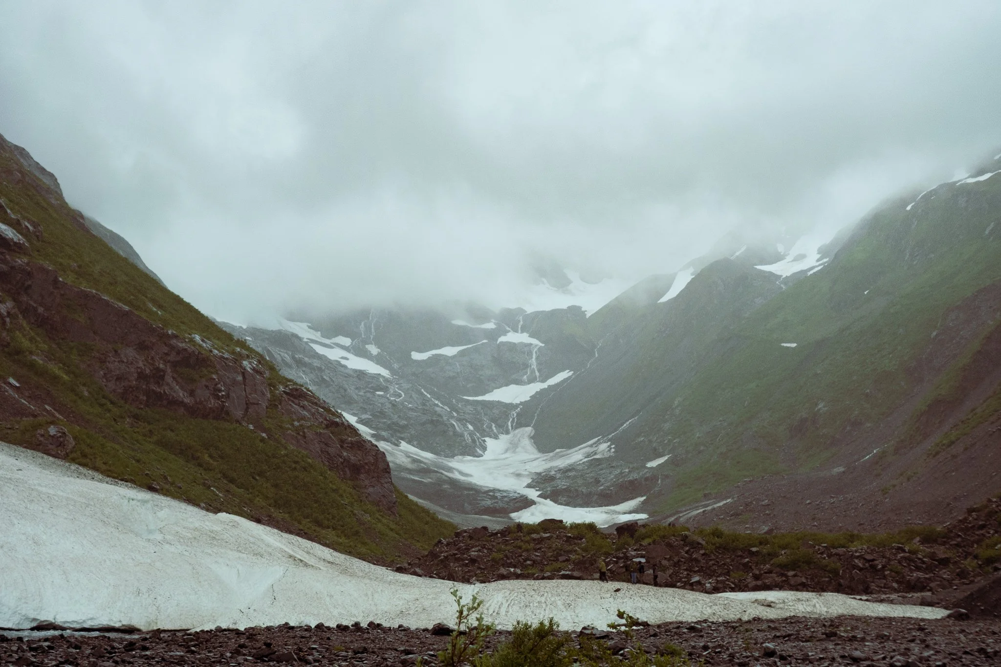 fog over the ice and black rock of Byron glacier in Alaska