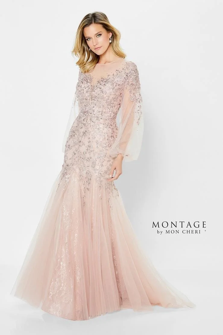 A woman in a long, elegant pink evening gown with lace and tulle details, standing against a white background.