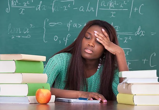 exhausted teacher sitting at her desk after school wondering if she should leave her job