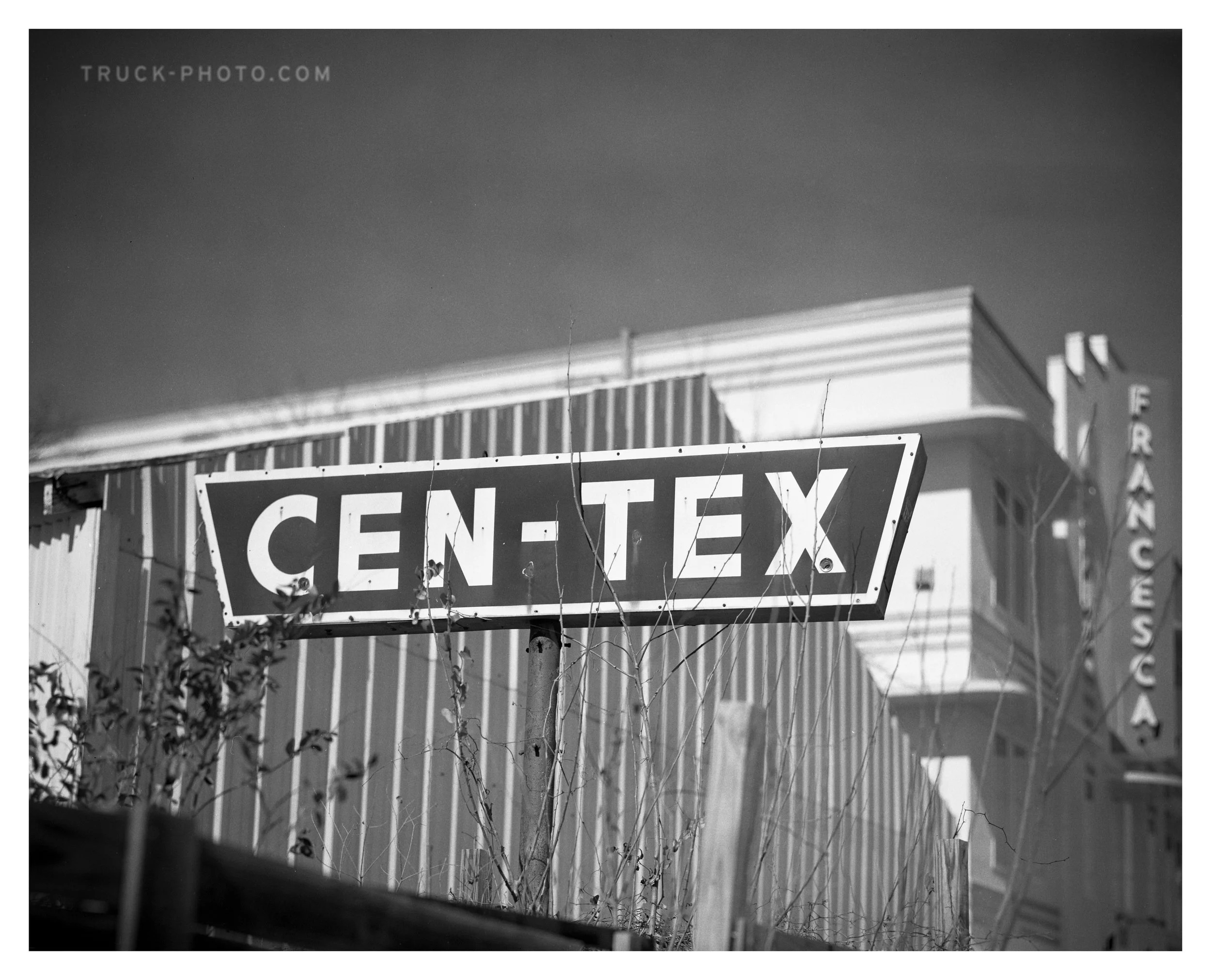 Black and white photo of a sign reading 'CEN-TEX' in front of a building.