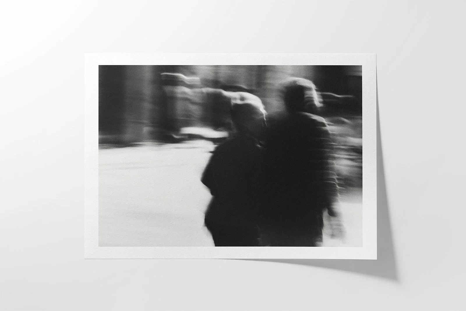 Blurred black and white image of two people walking outdoors.