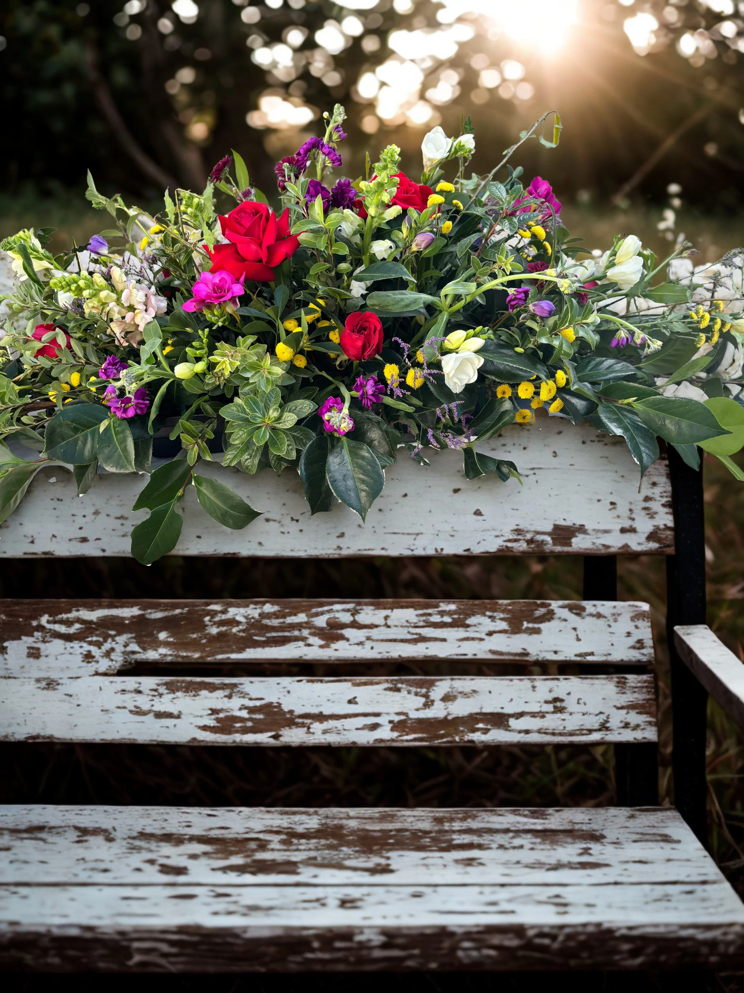 A casket spray with colourful garden flowers careully design to look like it's been removed straight from a garden bed. made fresh with same-day delivery in Havelock North, Hastings and Napier