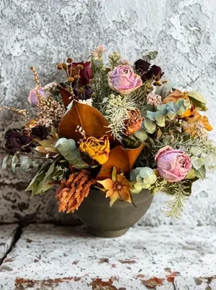 A Dried flower arrangement in a bowl featuring pink roses, foliage, yellow and purple flowers, everlasting blooms delivered Havelock North Hastings and Napier