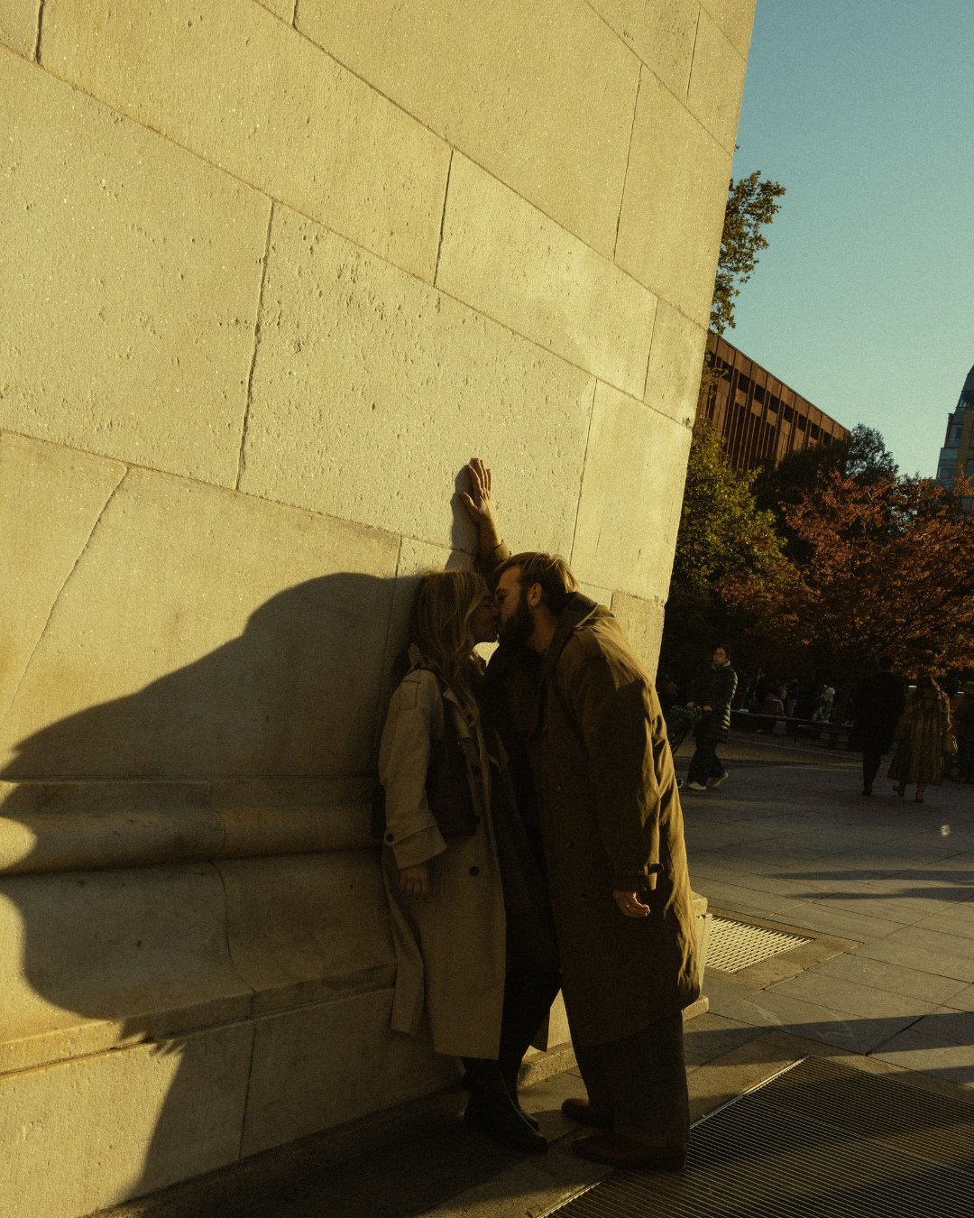 Couple under Washington Square Park arch at golden hour