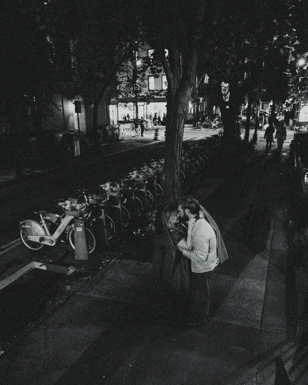 Couple under trench coat in West Village, black and white