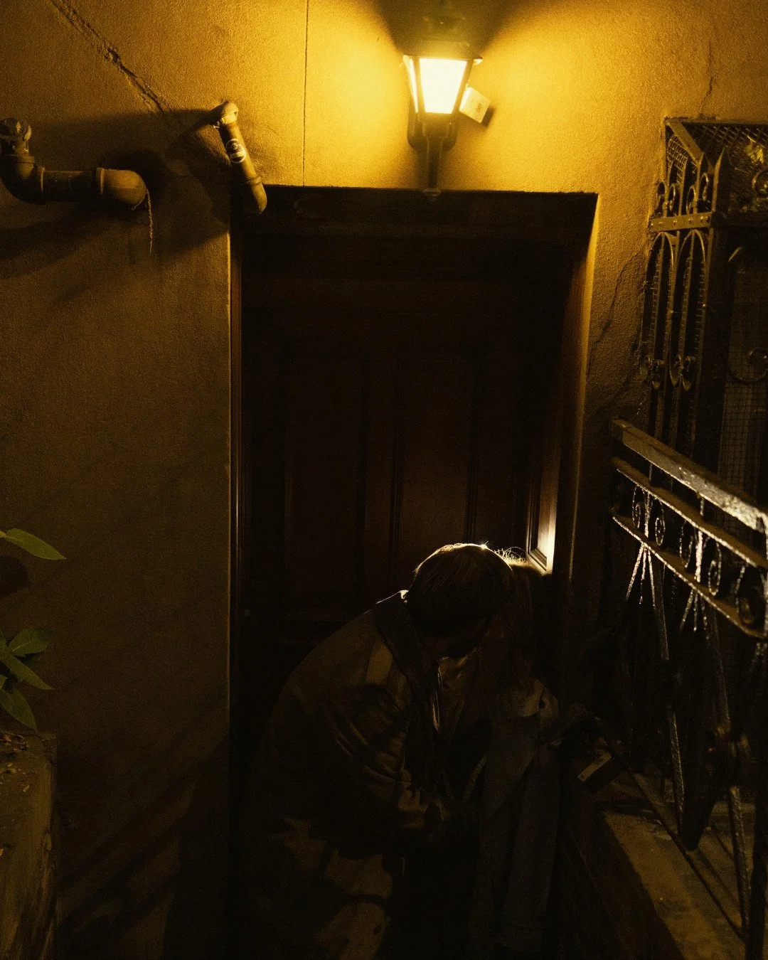 Couple making out at stairwell under street lamp in West Village