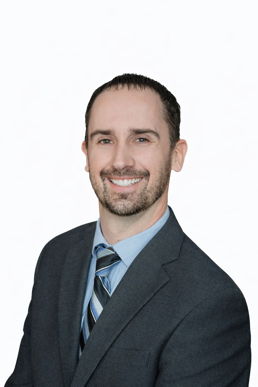 Man smiling in a suit and tie against a gray background.
