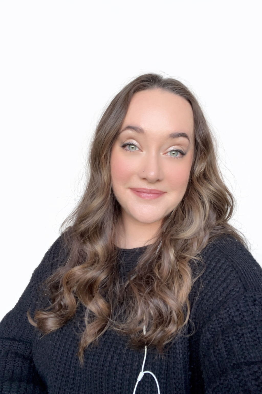 Smiling woman with long curly hair and a black sweater.