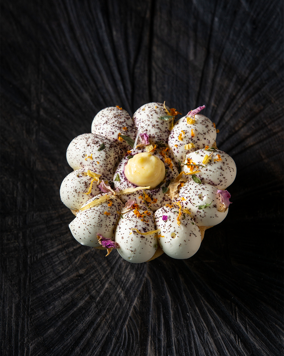 Ein Creme Dessert mit Blüten verziert vom La Sonett, inszeniert vom Studio für Branding Doppelpaula.