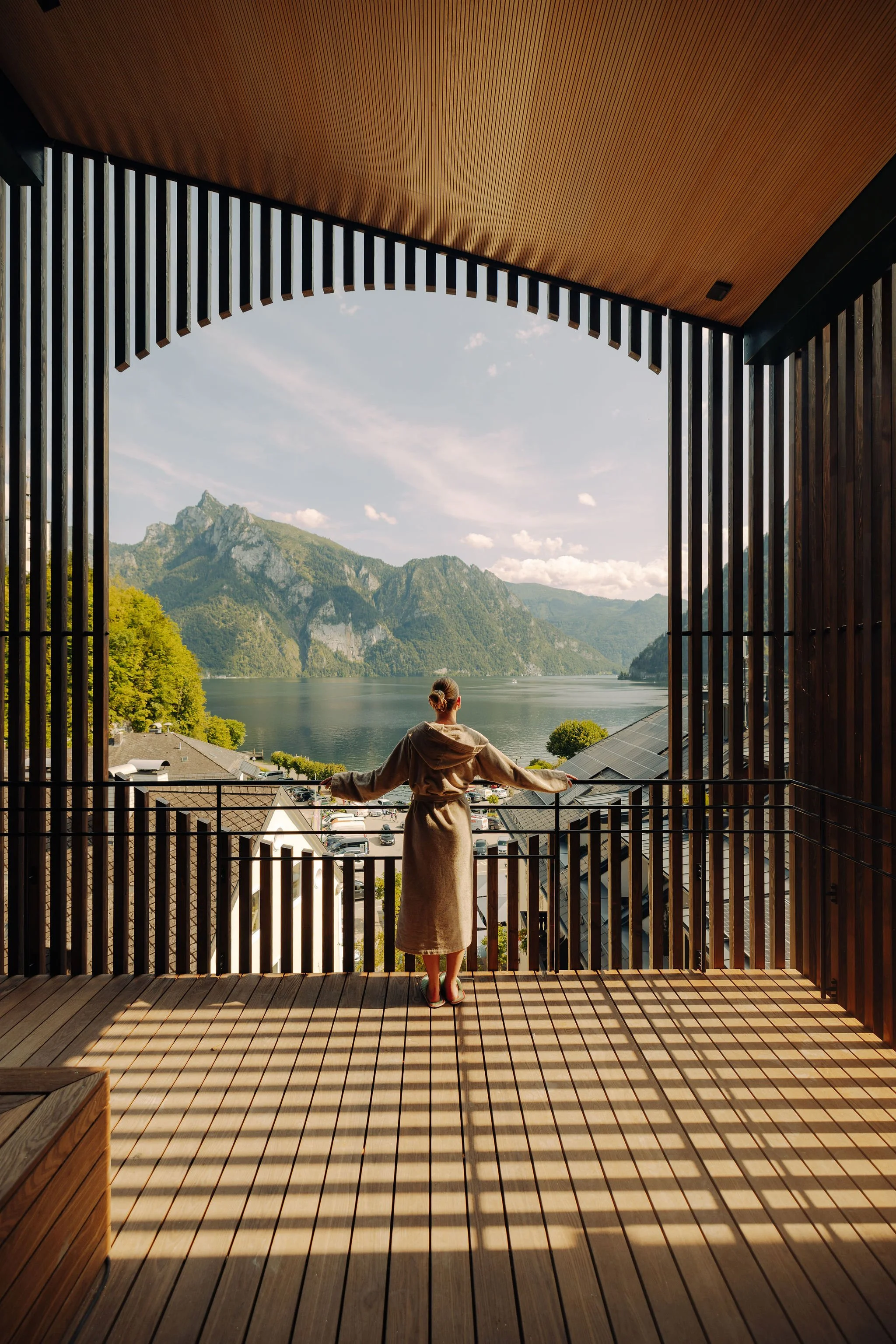 Eine Person steht auf einem Balkon und schaut auf die schöne Aussicht, inszeniert vom Studio für Branding Doppelpaula.