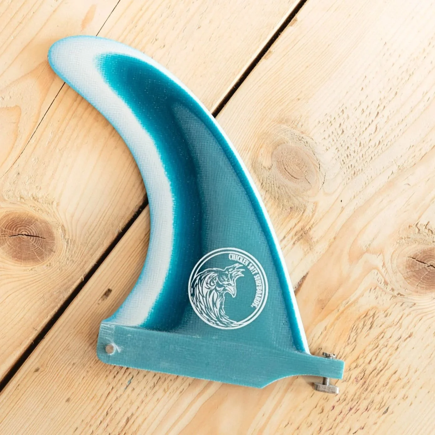 A blue and white plastic handheld device with a lion logo and the text 'Chicken Send' on it, placed on a wooden surface.