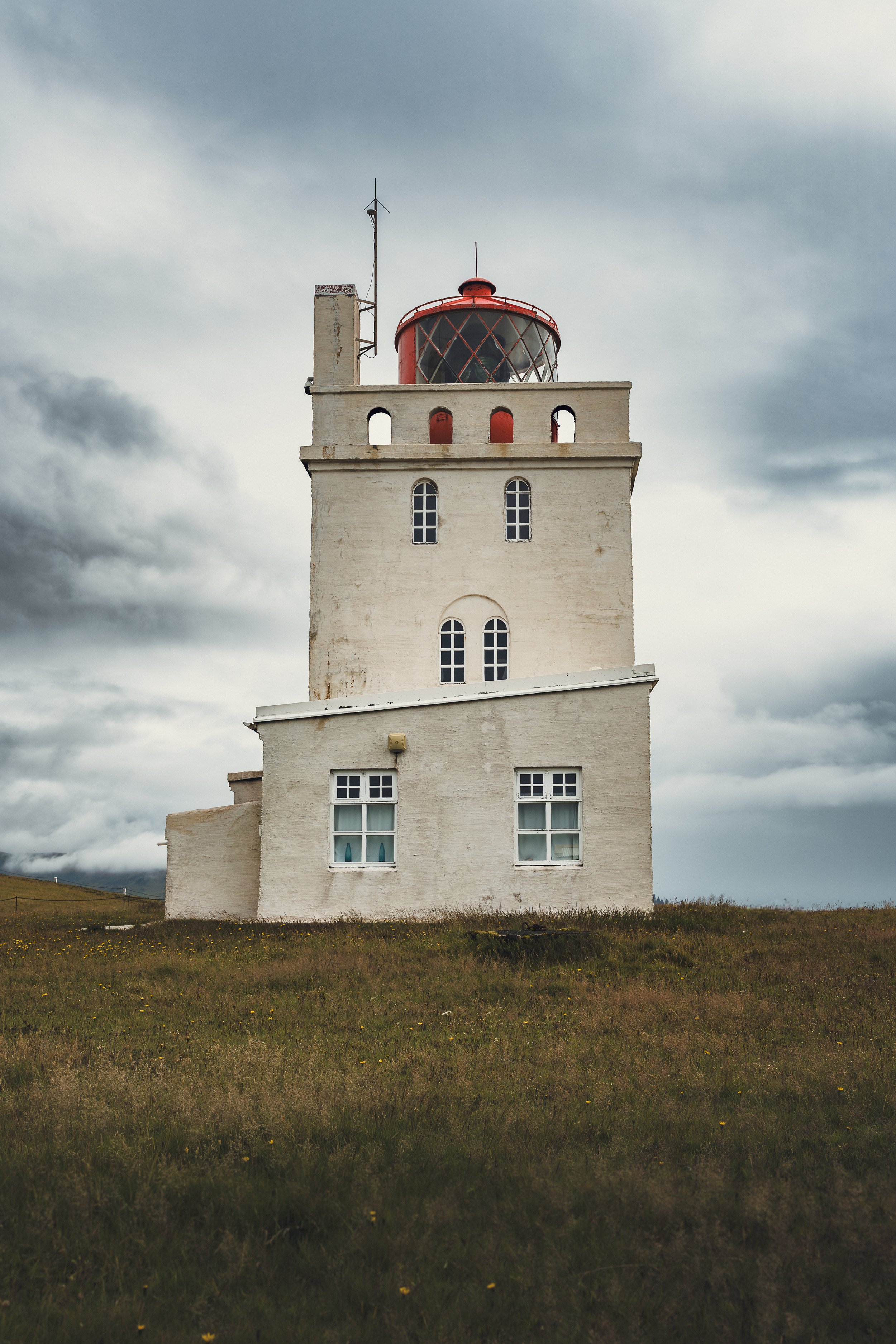 Perched on the windswept cliffs of Dyrhólaey, this lighthouse stands where the land finally gives way to the open sea. Weathered by time and surrounded by silence, it watches over the southern coast of Iceland with quiet resilience. Captured under he