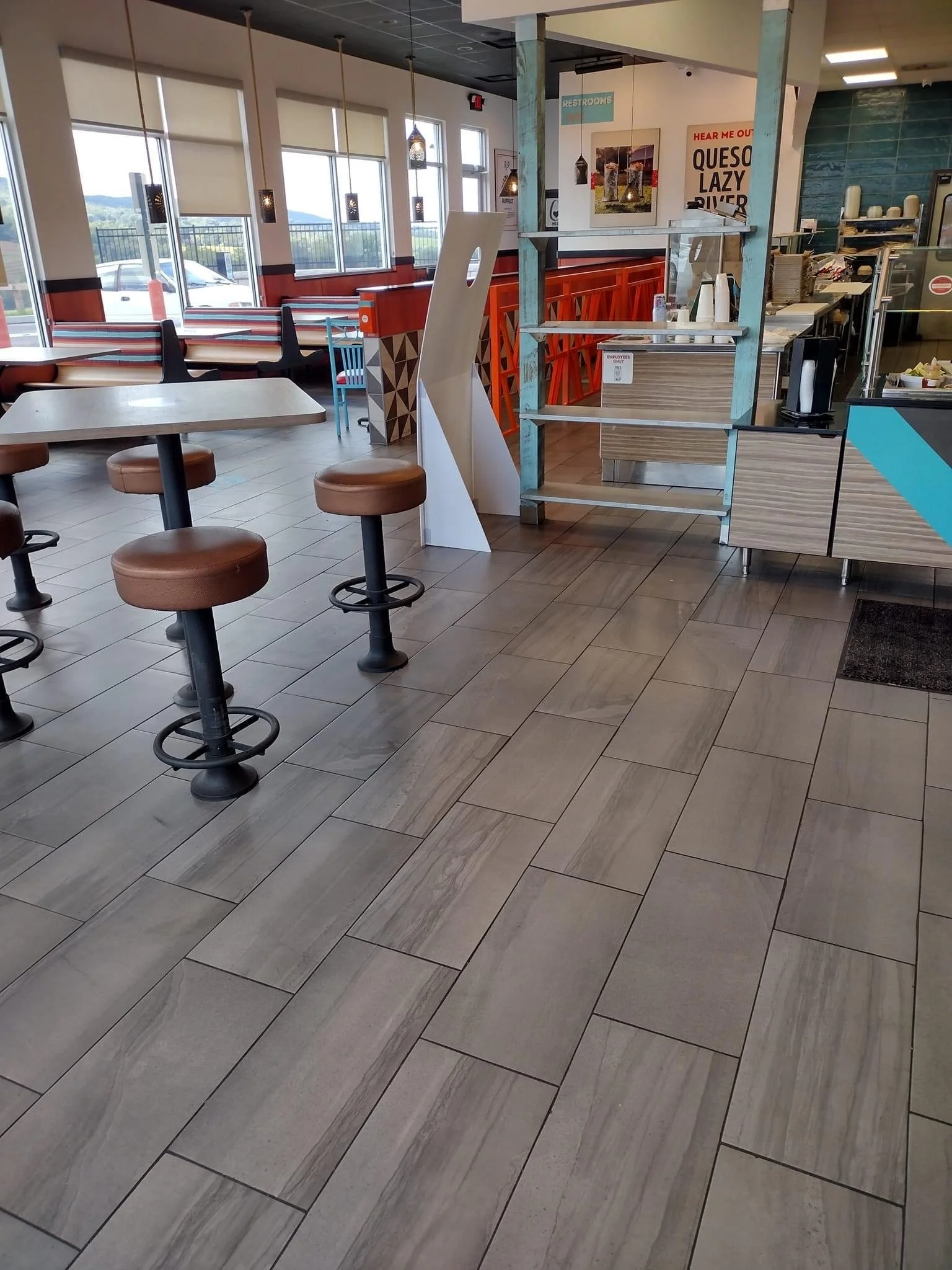 Interior of fast food restaurant with tables, stools, and counter