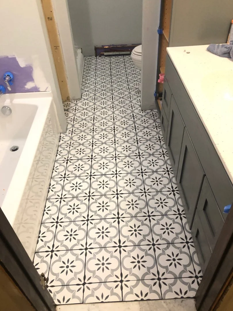 Bathroom with patterned tile floor, a bathtub, vanity, and toilet.