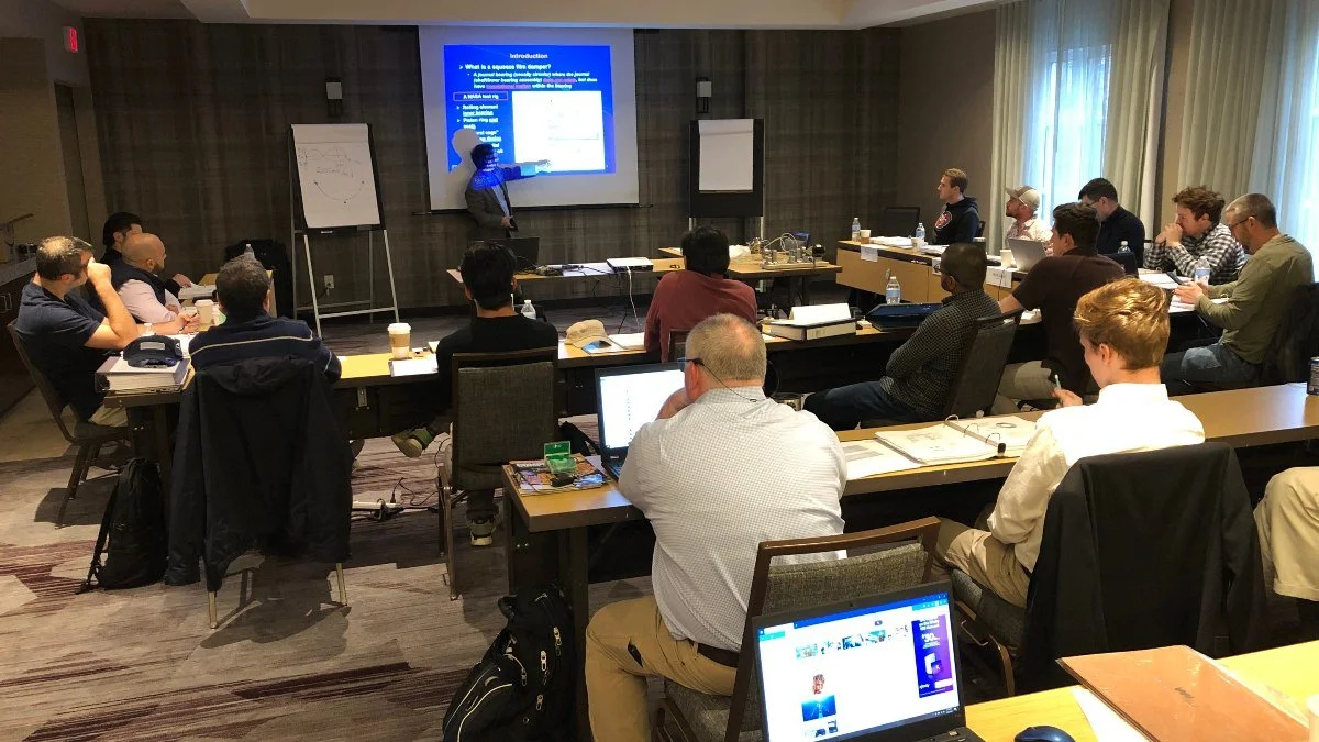 Course participants in a hotel conference room listening to a lecture on rotordynamics