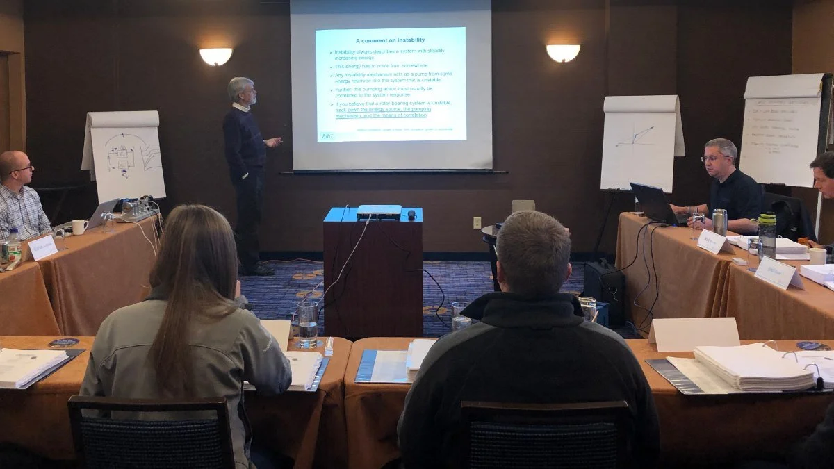 Course participants in a hotel conference room listening to a lecture on rotordynamics