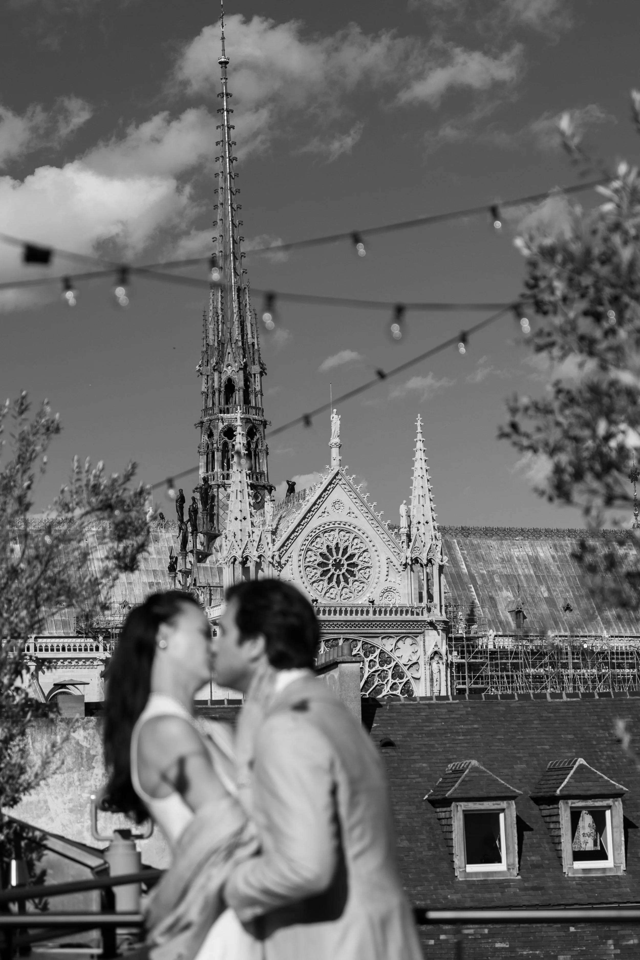 Destination elopement ou mariage civil romantique à Paris ? Séance photo de couple américain s’embrassant sur le rooftop du Philanthro-Lab devant Notre Dame prise par Patricia Hendrychova-Estanguet, photographe professionnelle de mariages intimistes