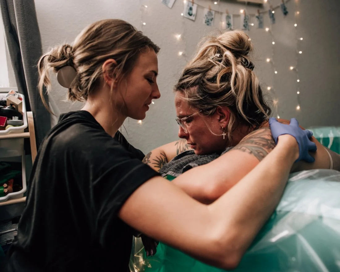 Trauma Informed Doula supporting a birthing mother in a birth tub with calm, grounded presence