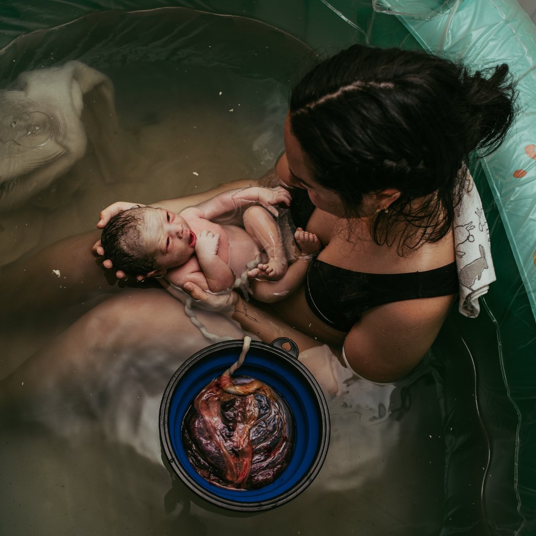 Mother with newborn baby in birth tub with placenta nearby during a peaceful Home Birth in Cheyenne, Wyoming