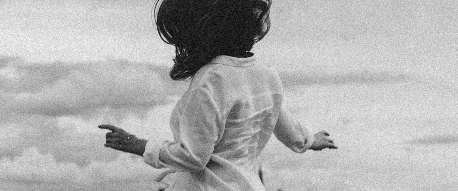 Pagina Manifesto: Branding intuitivo unisce design intenzionale e cura visiva per riflettere chi sei e la tua visione. Immagine: Donna di spalle, braccia aperte, bianco e nero.