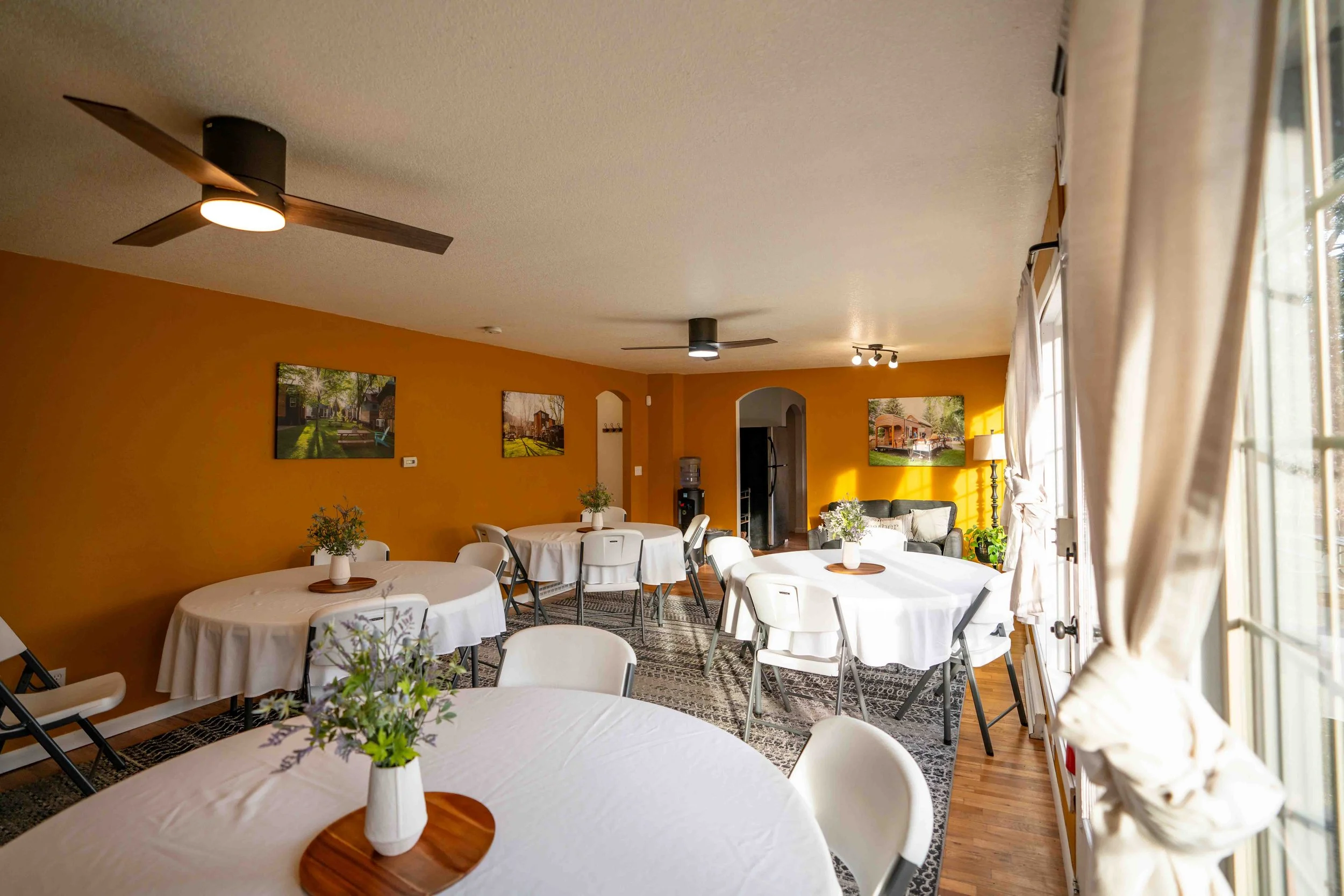 The WeeGather space at WeeCasa set up for a group meeting with circle tables adorned with centerpieces and spaces to connect.