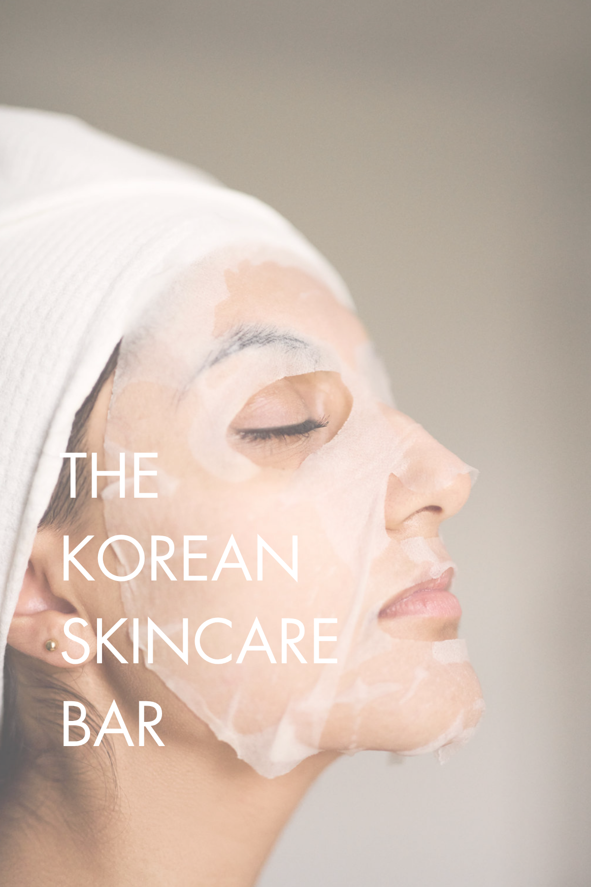 A woman with a white facial mask and a headband, close-up side profile with eyes closed, accompanied by the text 'The Korean Skincare Bar'