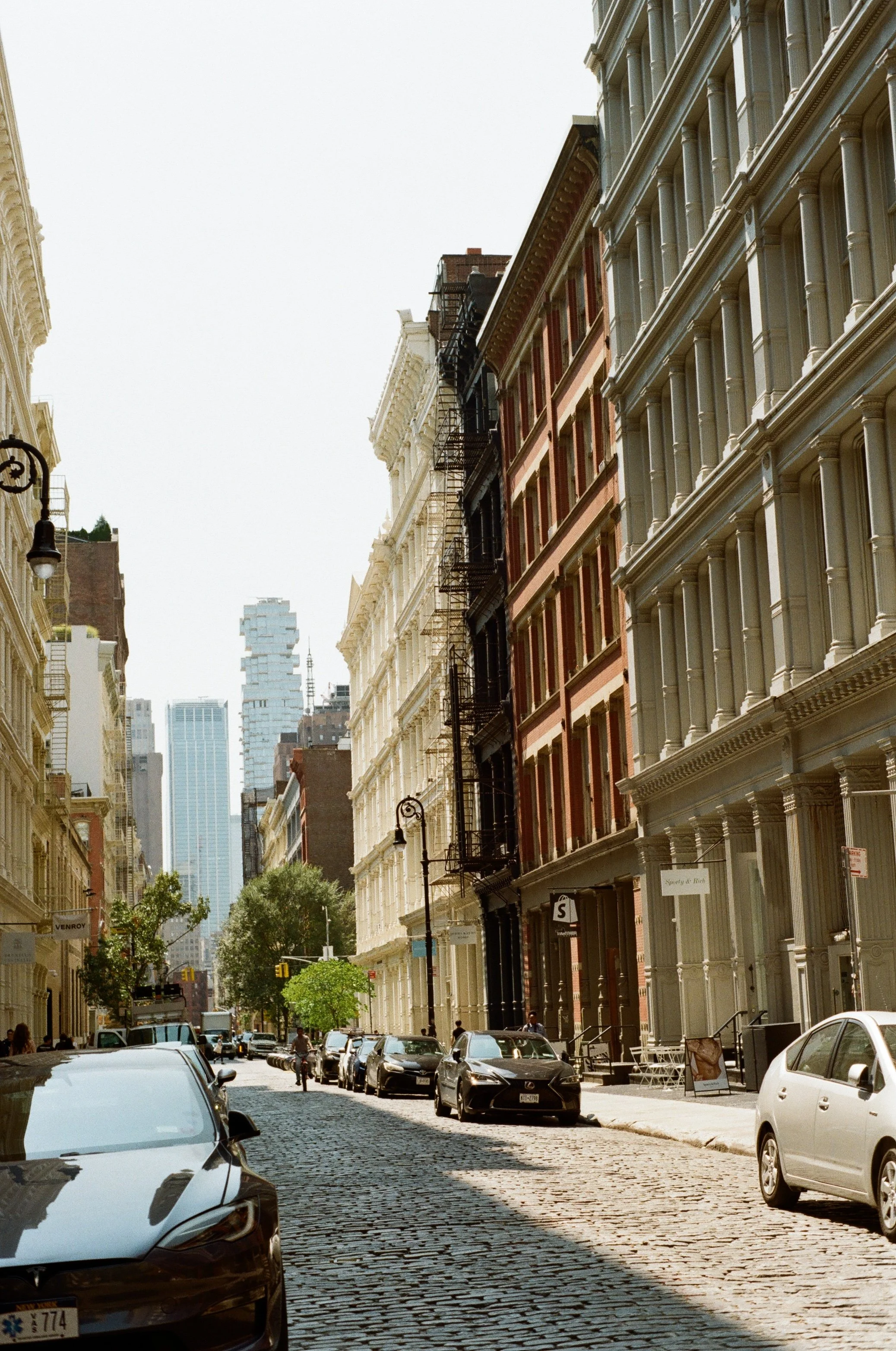 cobblestone street in New York City with historic buildings and modern skyscrapers in background