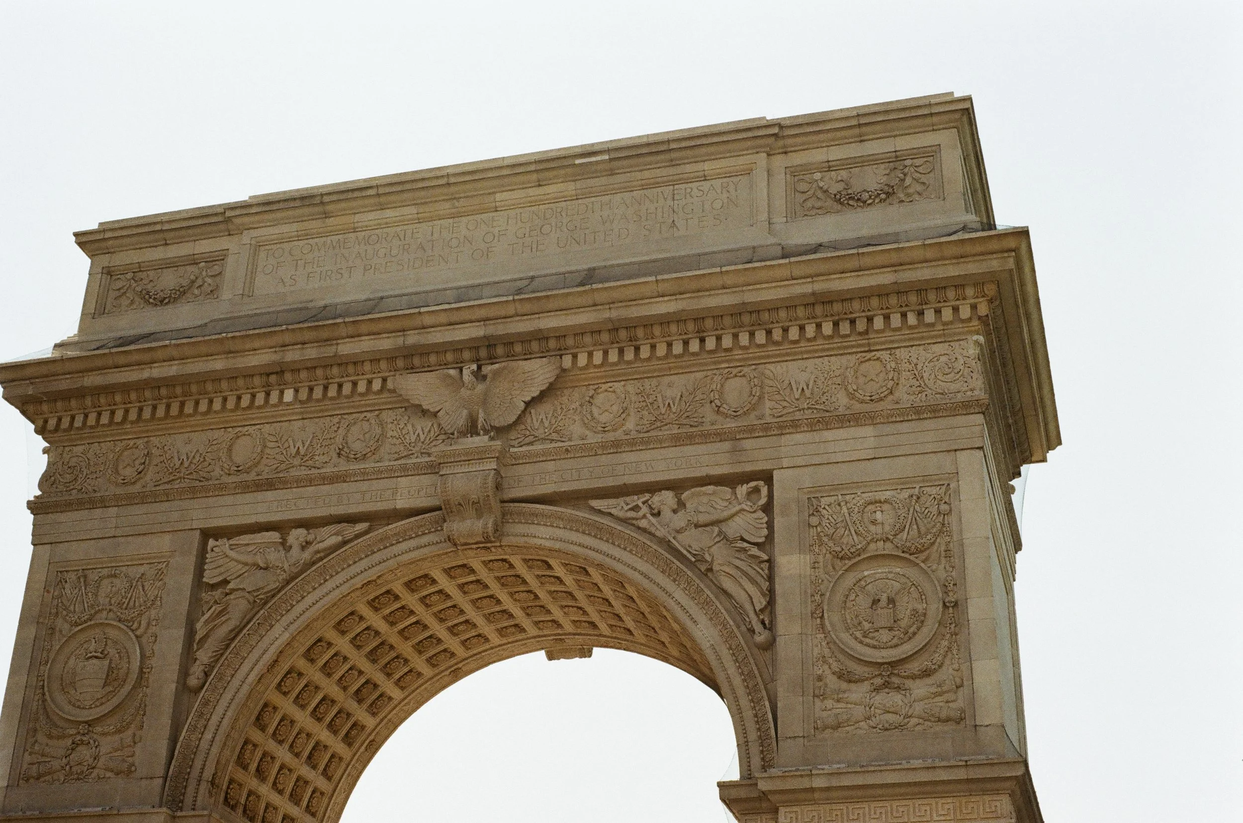 Close-up of an ornate stone arch with detailed sculptures and engraved inscriptions.