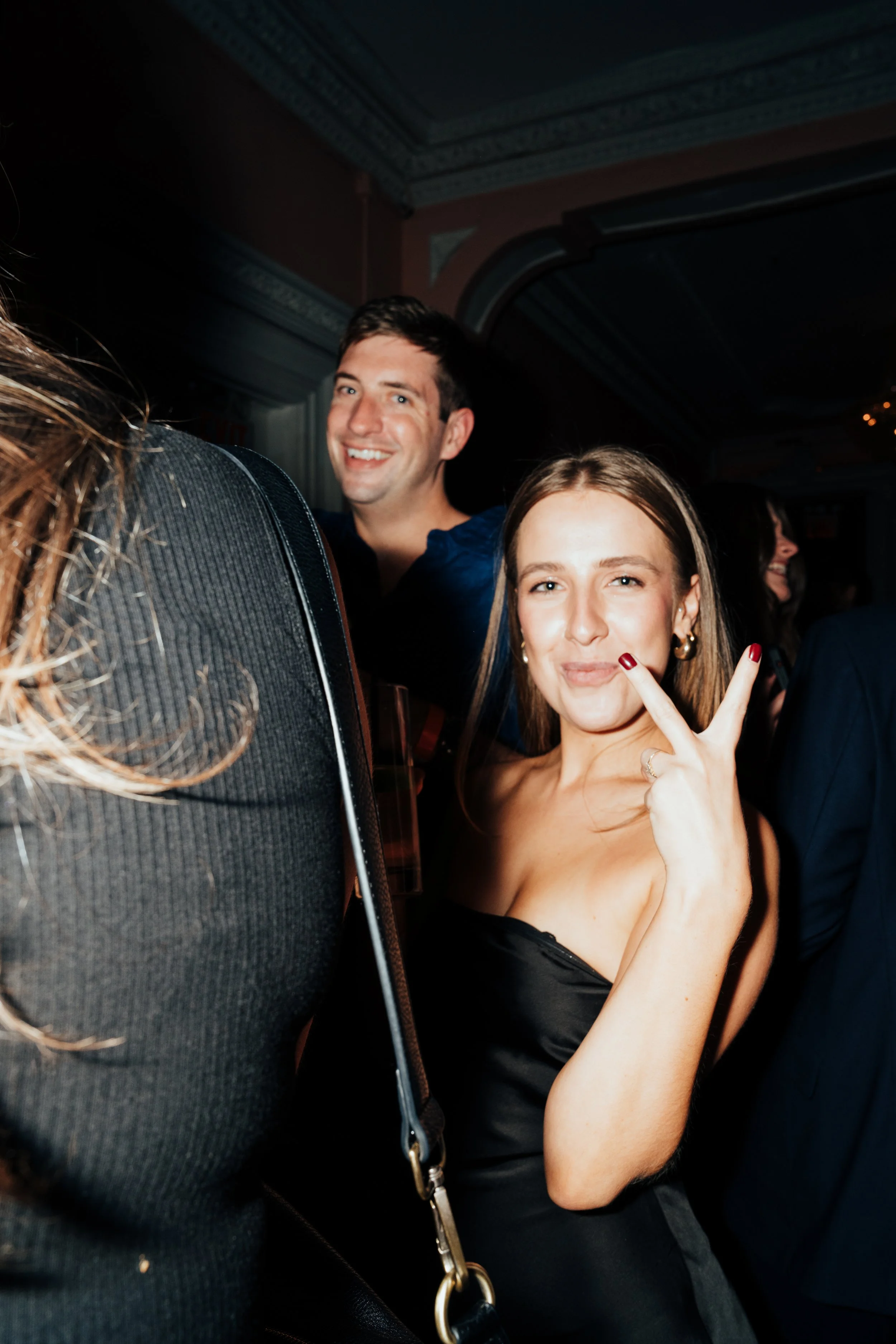 People at a party, smiling and posing with a peace sign at The Little Rebel in New York City, NY