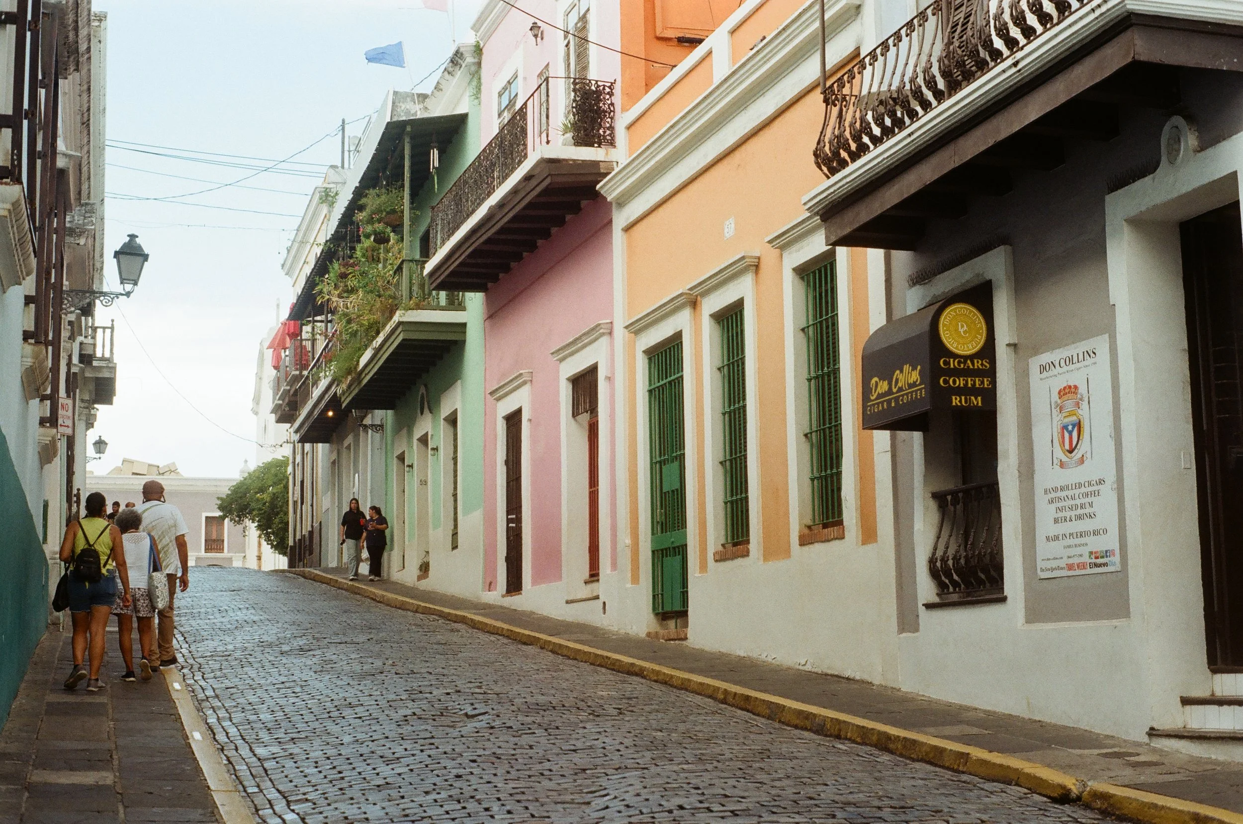 Cobbled street with colorful buildings and pedestrians in San Juan, Puerto Rico