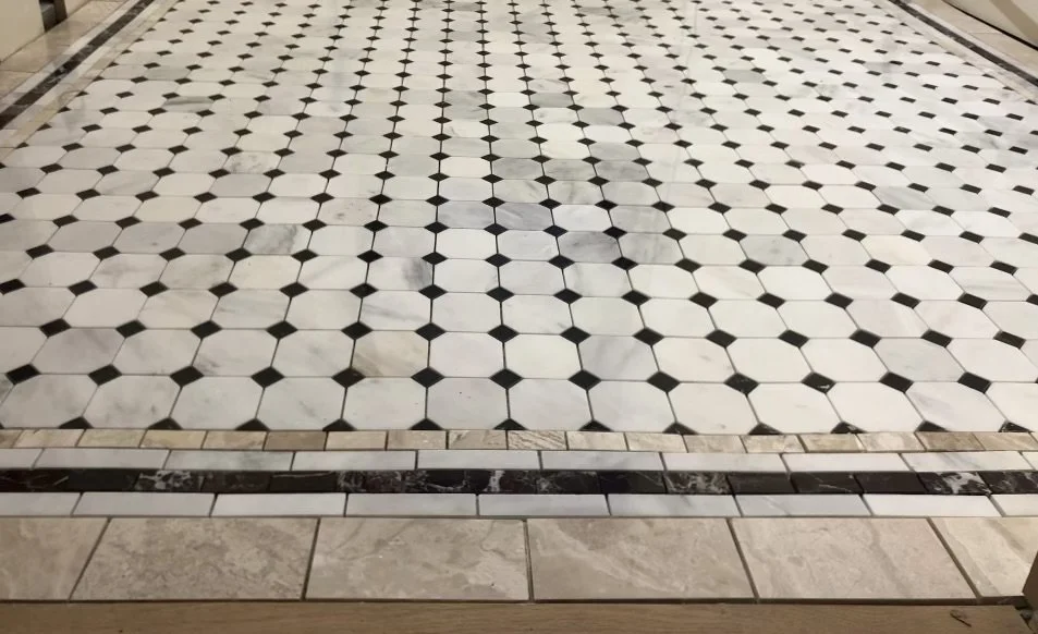 Black and white checkered tile floor with a decorative border around the edge.