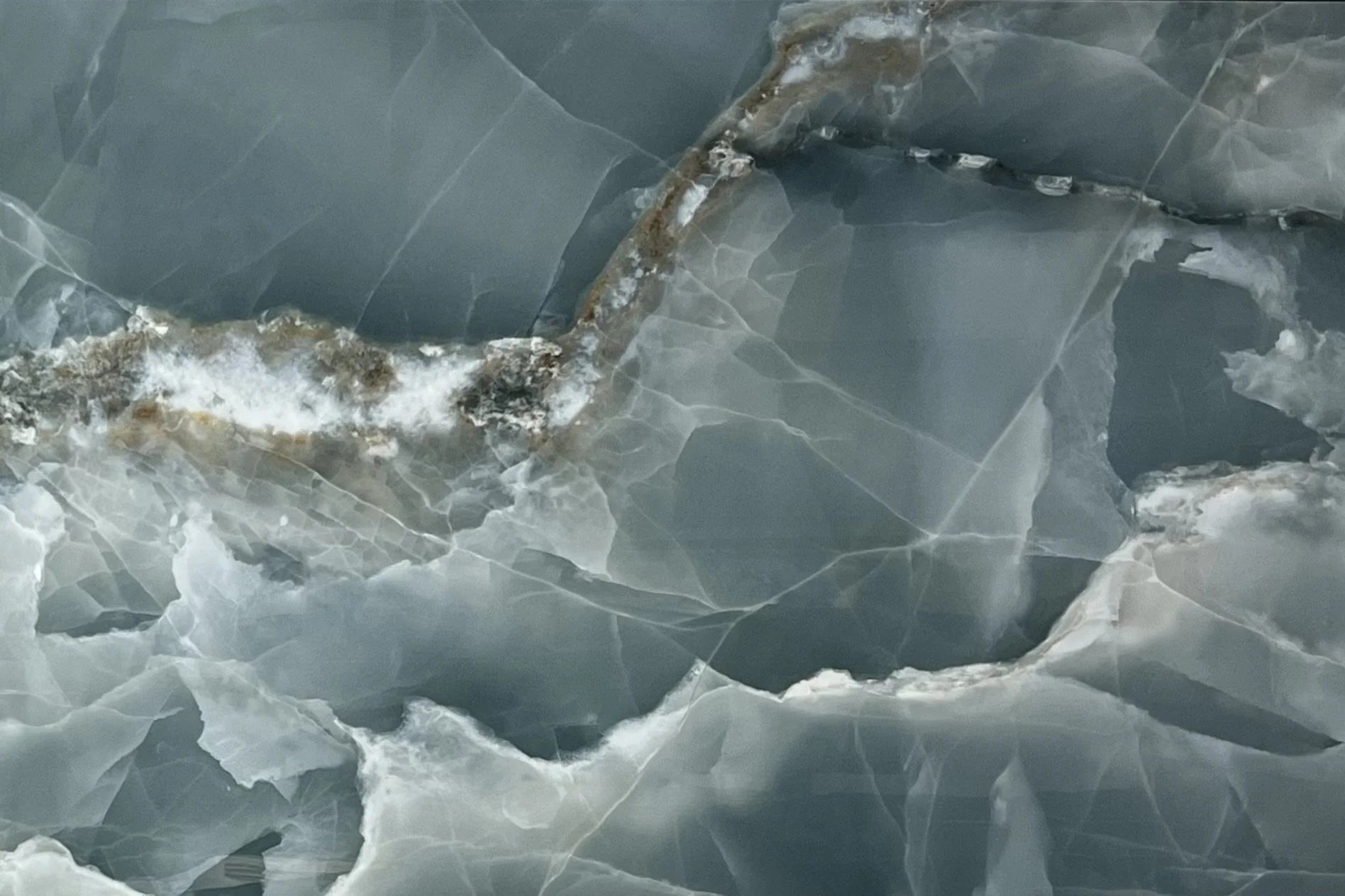 Close-up of a cracked and fractured ice surface with jagged edges and a rusty metal pipe partially embedded within the ice.