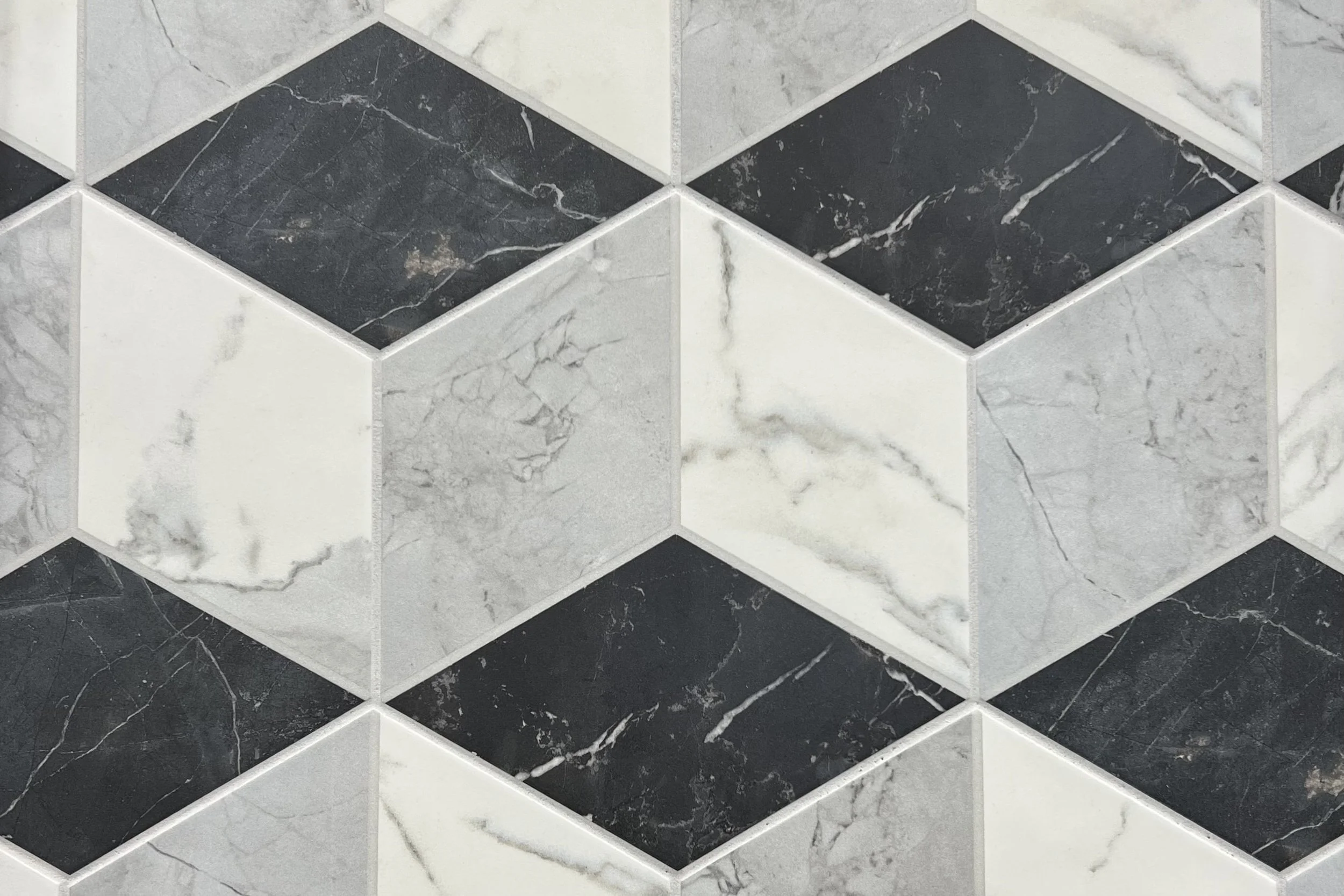A tiled wall with black, white, and gray marble-patterned tiles arranged in a diamond pattern.