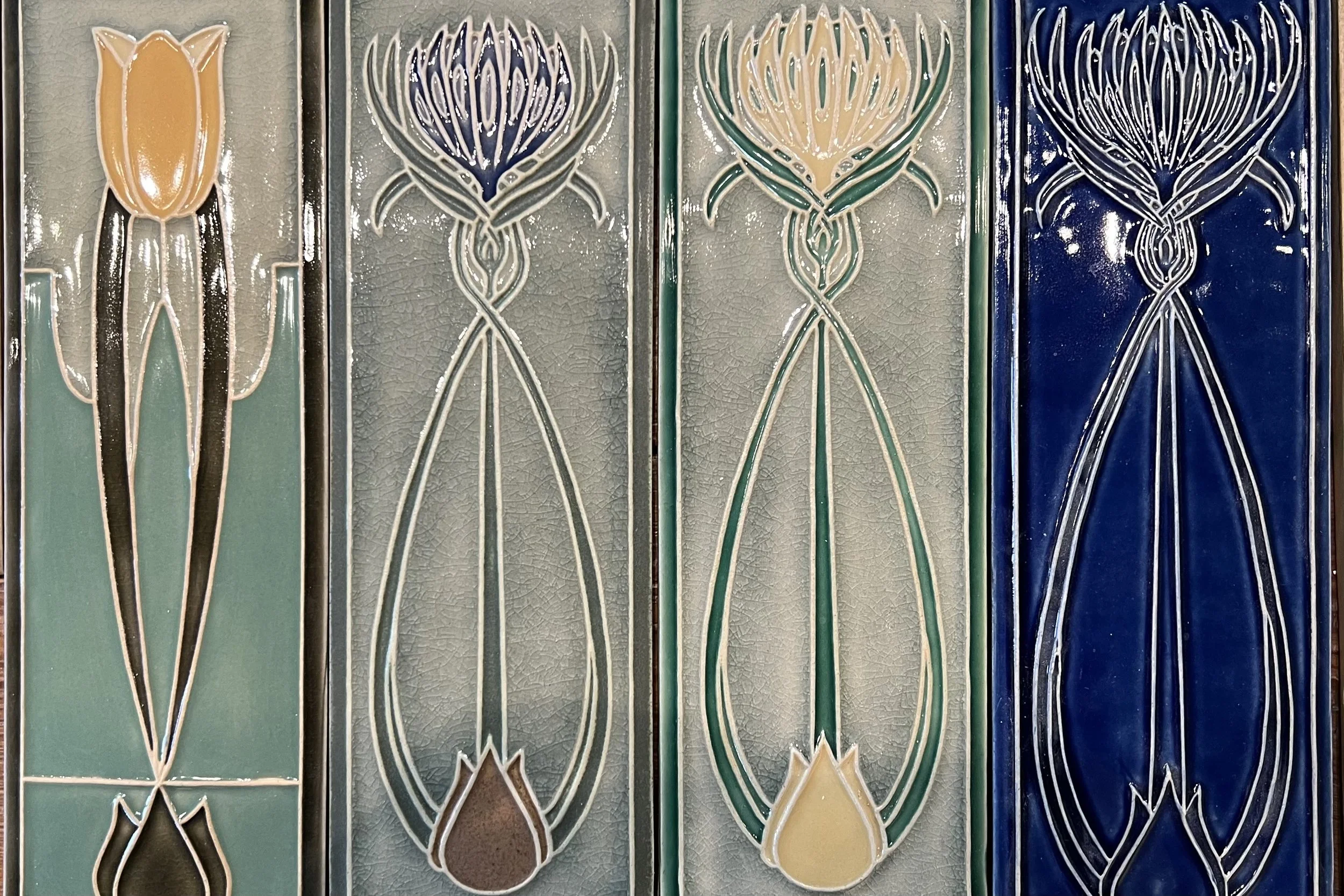 Decorative ceramic tiles featuring stylized floral patterns in pastel yellow, green, blue, and beige colors.