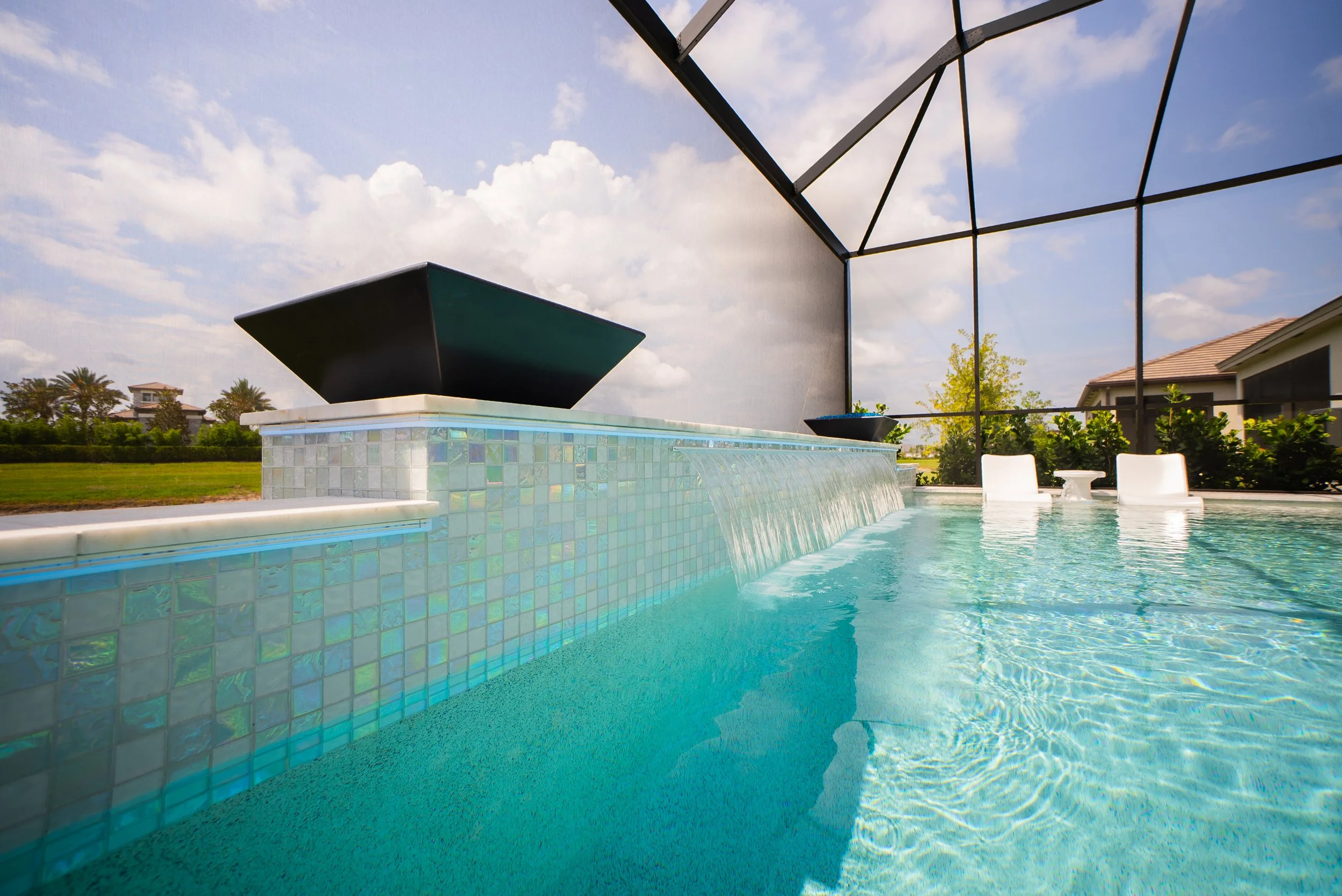 Beautiful new swimming pool in Pasco County, Florida with irridescent tiles and fire bowls