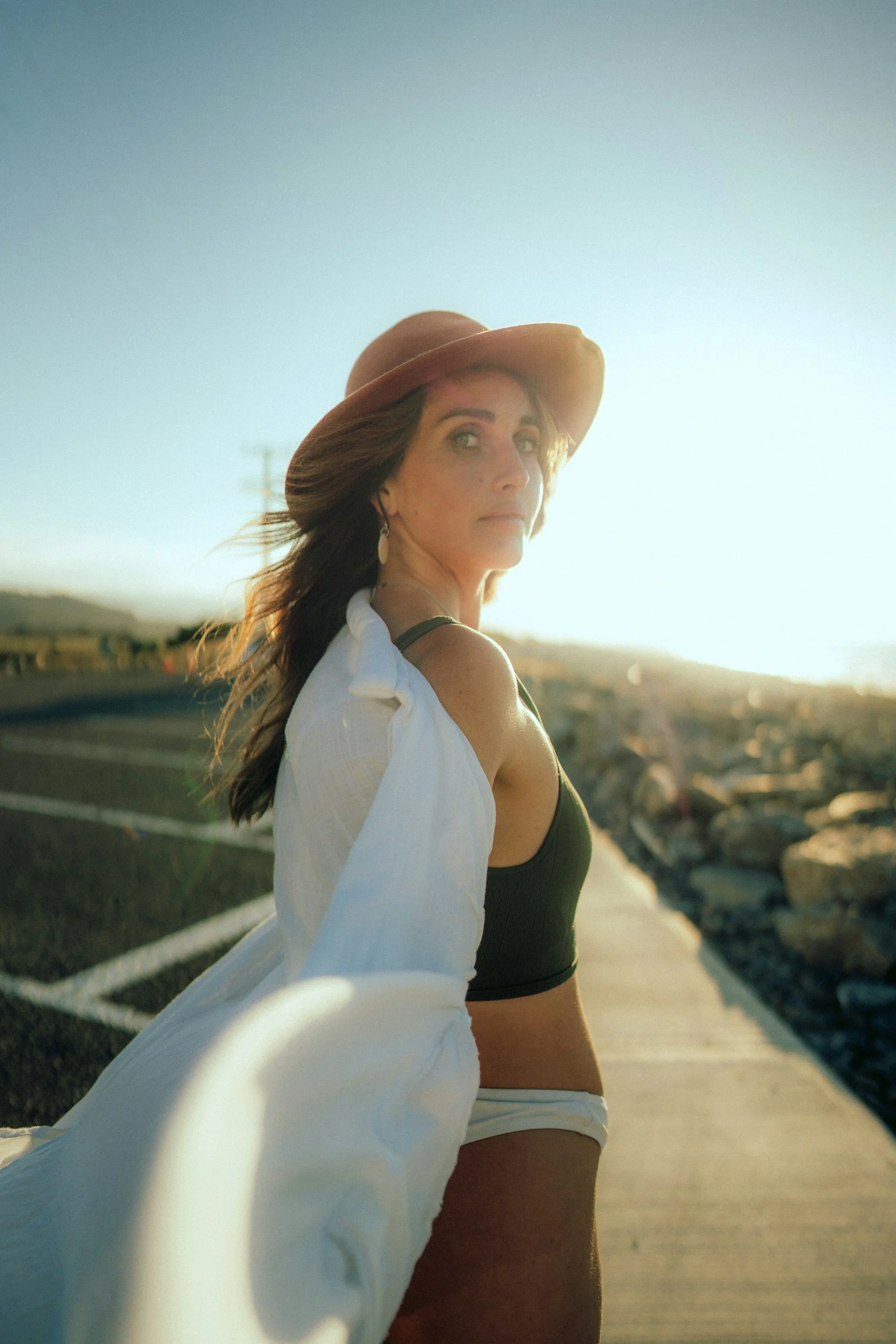 Woman wearing a sun hat outdoors in warm sunlight.