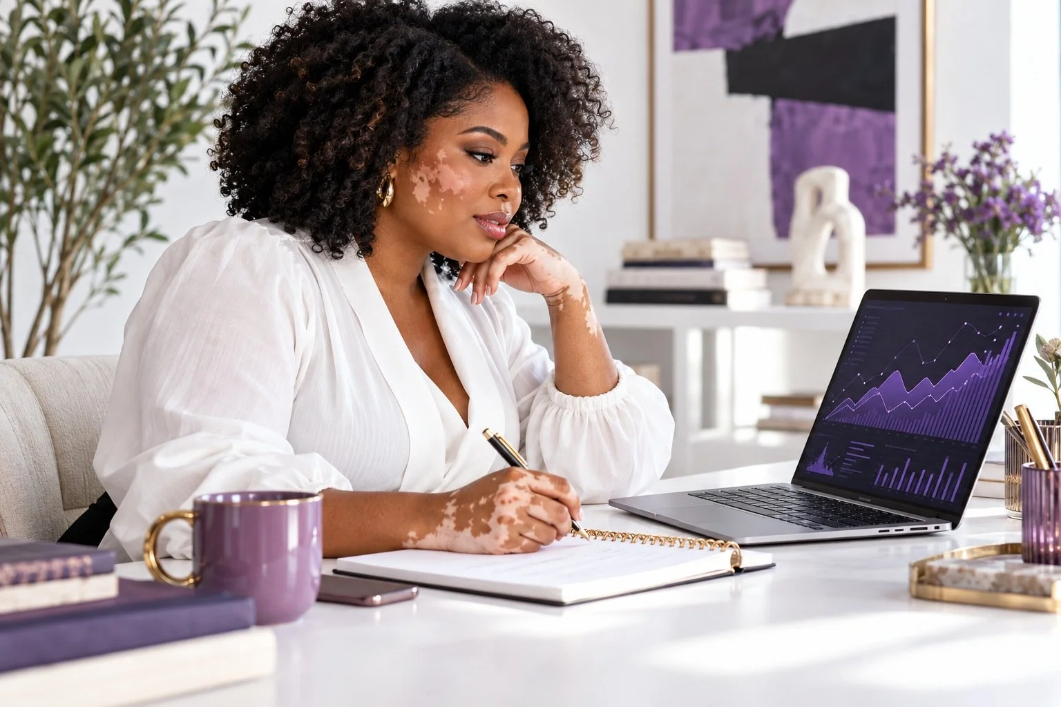 Woman studying a financial chart on a laptop and taking notes.