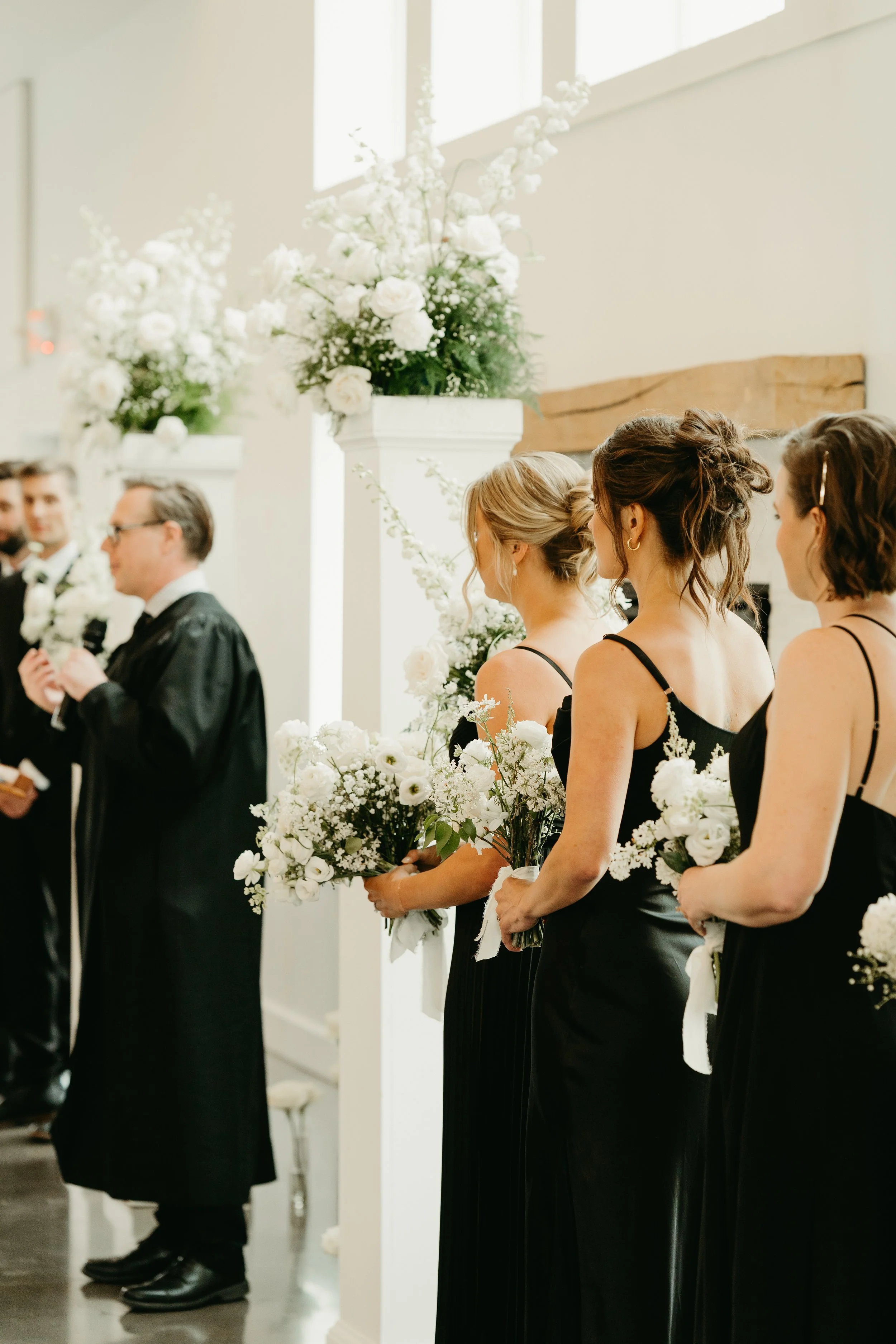 Black and white bridesmaid flowers with altar flowers