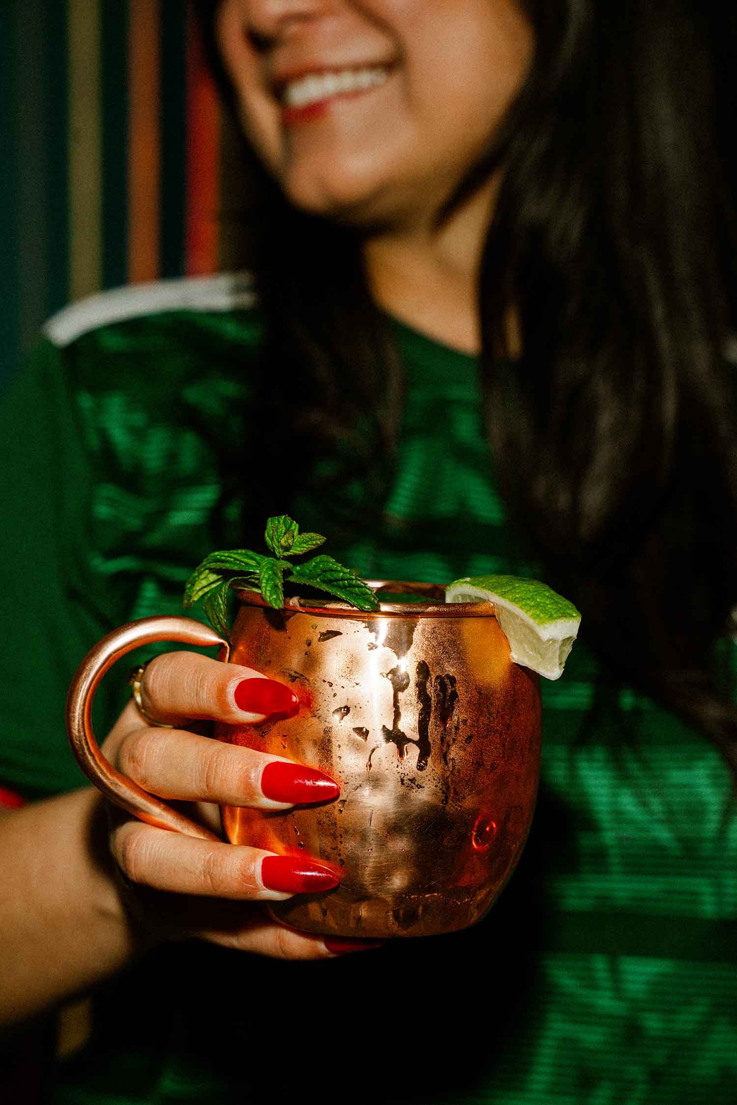 Latina influencer holding a styled copper Moscow Mule for a Houston branded social media content shoot