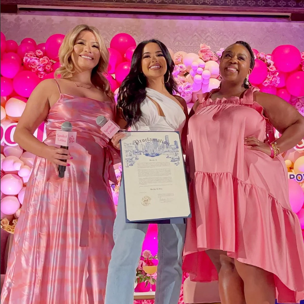 Yvonne Guidry, Houston entrepreneur and creator of Spoiled Latina, smiling on stage with two women at the Spoiled Latina Summit