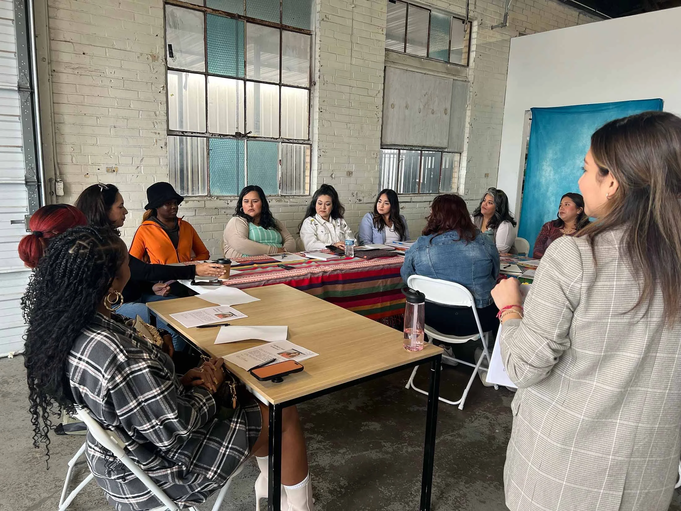 Rosa Pruneda leading a culture-led PR and social media strategy workshop for a diverse group of Latina small business owners in a Houston creative space
